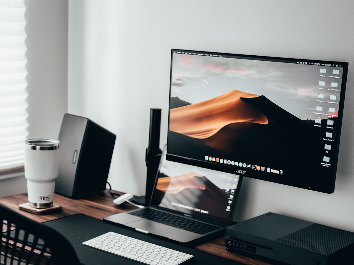 A tidy desk setup with laptop and monitor